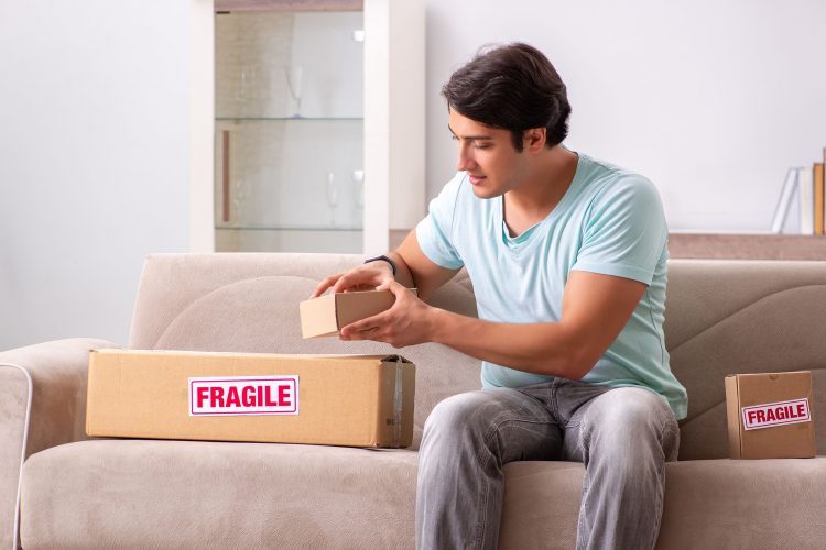 man packing fragile boxes